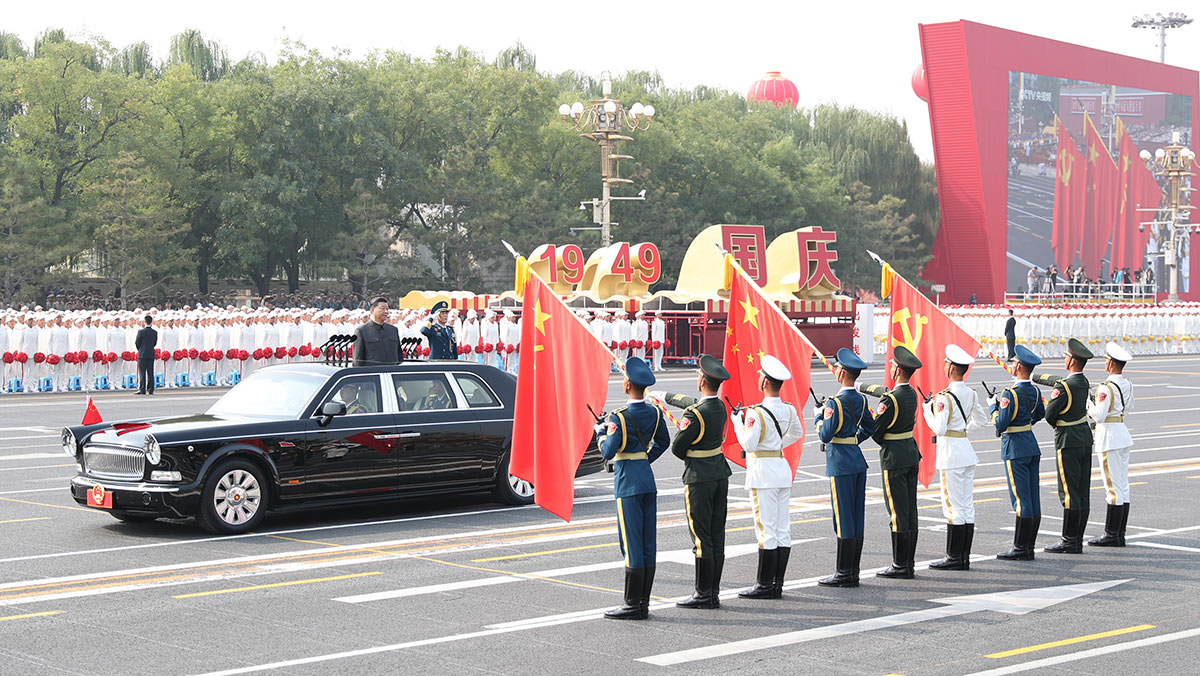 習(xí)近平驅(qū)車行進至黨旗、國旗、軍旗前，向旗幟行注目禮